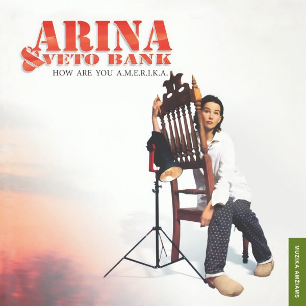 „Arina & VETO BANK – How Are You A.M.E.R.I.K.A.” albumo viršelis su Arina sėdinčia ant kėdės, perteikiantis retro roko estetiką.