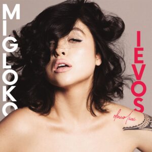 Migloko „Ievos obuoliai“ vinilo plokštelės viršelis – moters portretas su tamsiais, banguotais plaukais, dalinai dengiančiais veidą, minimalistinis fonas, kairėje baltas užrašas „Migloko“, dešinėje raudonas „Ievos“, apačioje matomas subtilus peties tatuiruotės fragmentas.