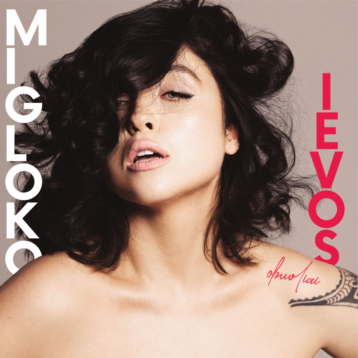 Migloko „Ievos obuoliai“ vinilo plokštelės viršelis – moters portretas su tamsiais, banguotais plaukais, dalinai dengiančiais veidą, minimalistinis fonas, kairėje baltas užrašas „Migloko“, dešinėje raudonas „Ievos“, apačioje matomas subtilus peties tatuiruotės fragmentas.